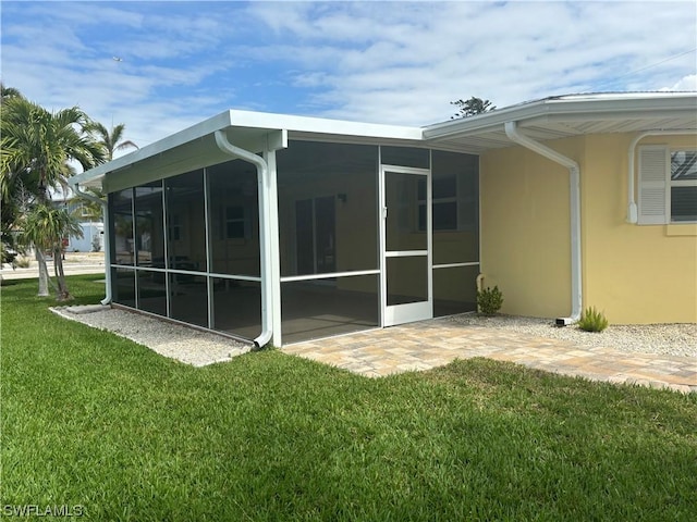 back of house with a lawn and a sunroom