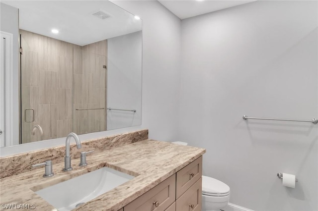 bathroom with vanity, toilet, and a shower with door