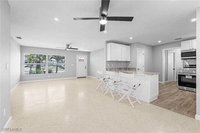 2 Fairview Blvd, Fort Myers Beach, FL 33931 - kitchen with stainless steel appliances, ceiling fan, baseboards, white cabinetry, and a peninsula