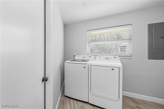 2 Fairview Blvd, Fort Myers Beach, FL 33931 - laundry area with independent washer and dryer, electric panel, baseboards, and light wood-style flooring