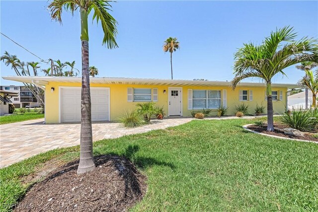 2 Fairview Blvd, Fort Myers Beach, FL 33931 - ranch-style home featuring an attached garage, decorative driveway, stucco siding, and a front yard