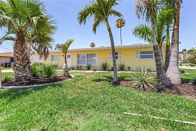 2 Fairview Blvd, Fort Myers Beach, FL 33931 - view of front of house with stucco siding and a front lawn