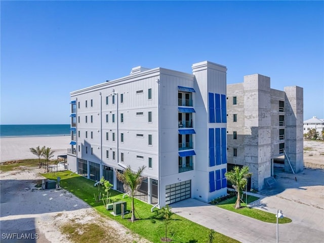 6230 Estero Blvd Unit 202, Fort Myers Beach, FL 33931 - view of property featuring a view of the beach, driveway, a water view, a garage, and central air condition unit