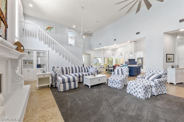 tiled living room with ceiling fan and a towering ceiling