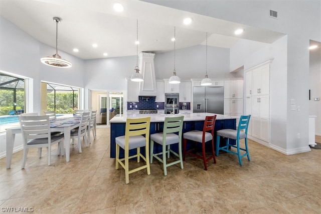 tiled dining area with high vaulted ceiling, an inviting chandelier, and french doors