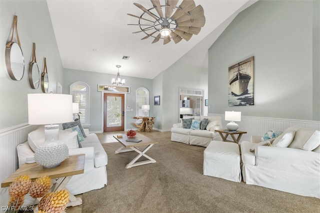 living room featuring lofted ceiling, a notable chandelier, and carpet floors