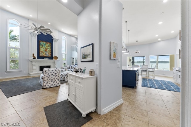 hall featuring light tile floors and a high ceiling