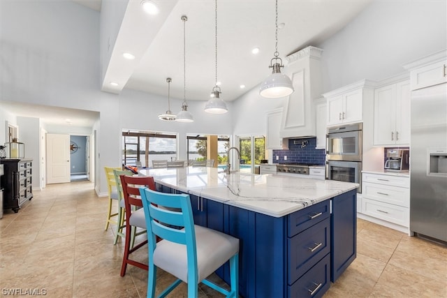 kitchen featuring appliances with stainless steel finishes, high vaulted ceiling, a breakfast bar area, and pendant lighting