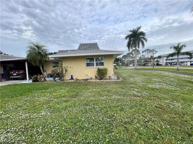 view of home's exterior featuring a lawn and a carport