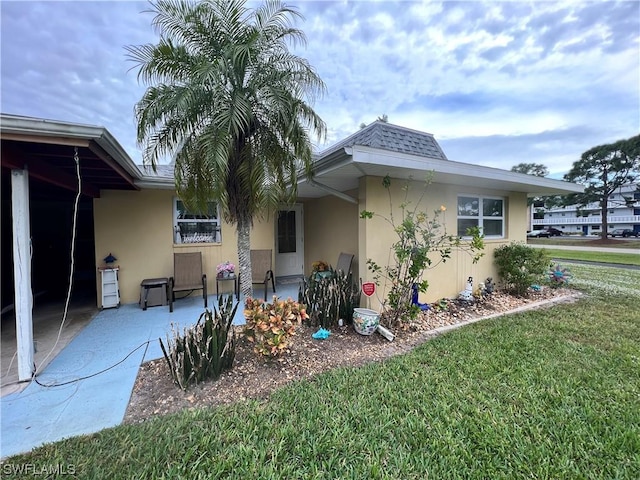 rear view of property featuring a lawn and a patio