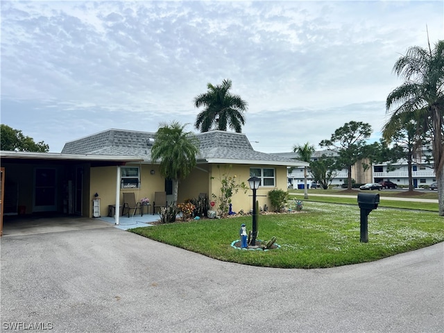 single story home featuring a front yard and a carport