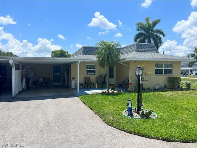 view of front of property with a carport and a front lawn