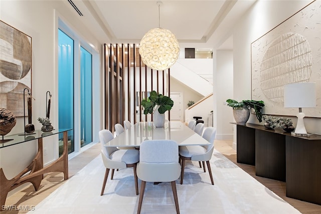 dining space featuring a chandelier and a raised ceiling