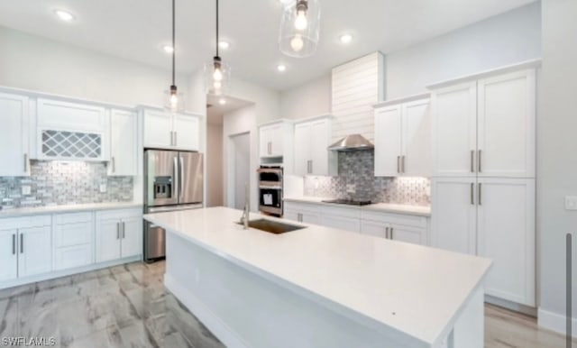 kitchen with sink, white cabinets, a center island with sink, stainless steel appliances, and tasteful backsplash