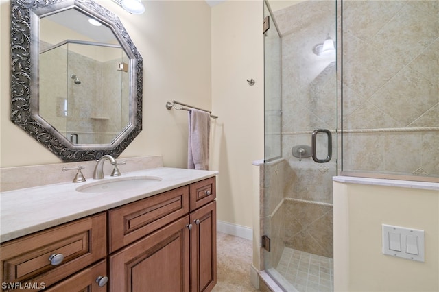 bathroom with a shower with shower door and vanity