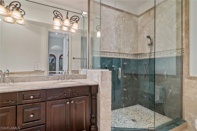 bathroom with double sink, a shower with shower door, and large vanity