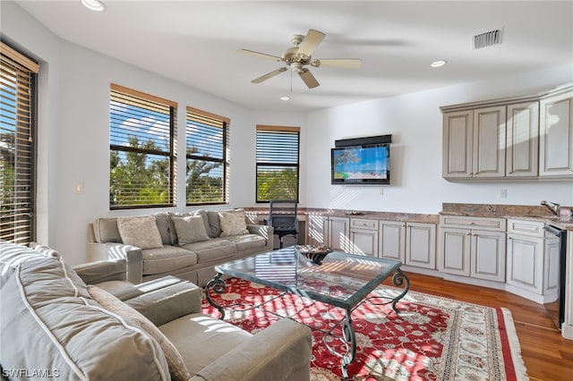 living room with ceiling fan, light wood-type flooring, and sink