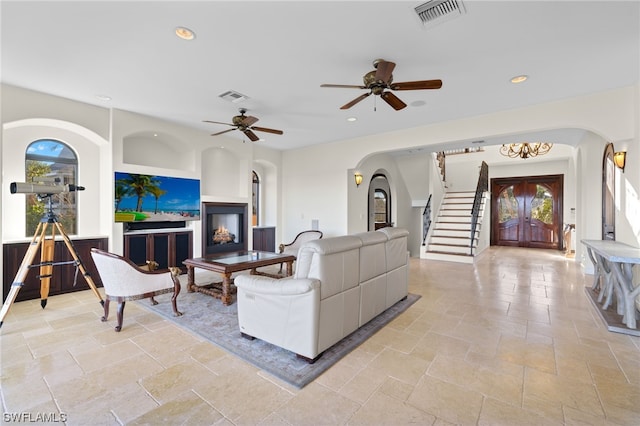 living room featuring light tile floors, ceiling fan, and a wealth of natural light