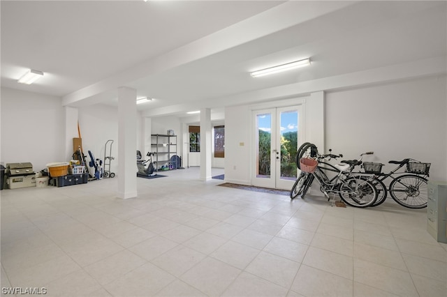 exercise room featuring light tile flooring and french doors