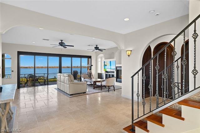 interior space with a water view and ceiling fan