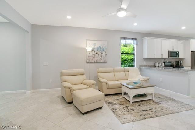 living room with light tile patterned flooring, baseboards, a ceiling fan, and recessed lighting