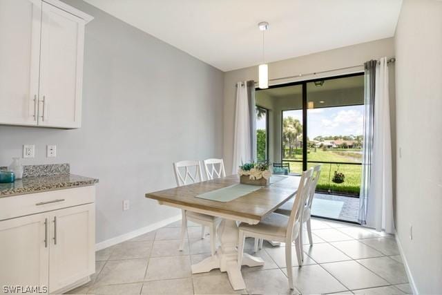 unfurnished dining area featuring baseboards and light tile patterned flooring