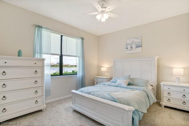 bedroom with a ceiling fan, light colored carpet, and baseboards