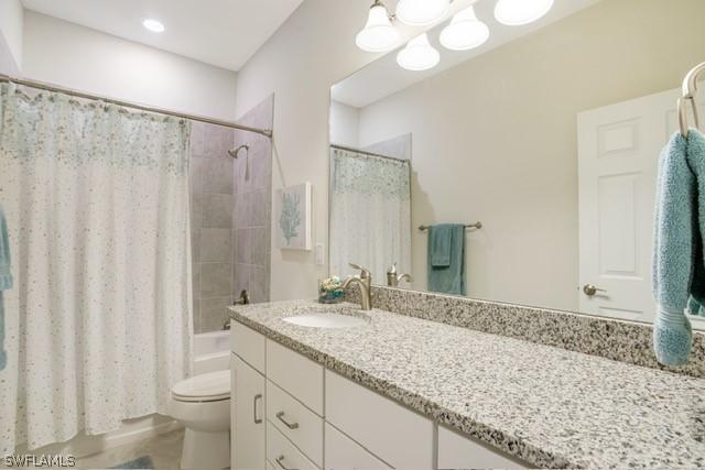 full bath featuring shower / bath combo, vanity, and toilet