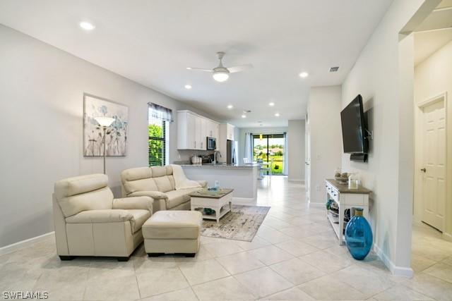 living area with a ceiling fan, recessed lighting, light tile patterned flooring, and a healthy amount of sunlight