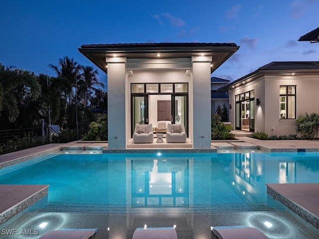 pool at dusk featuring a patio area