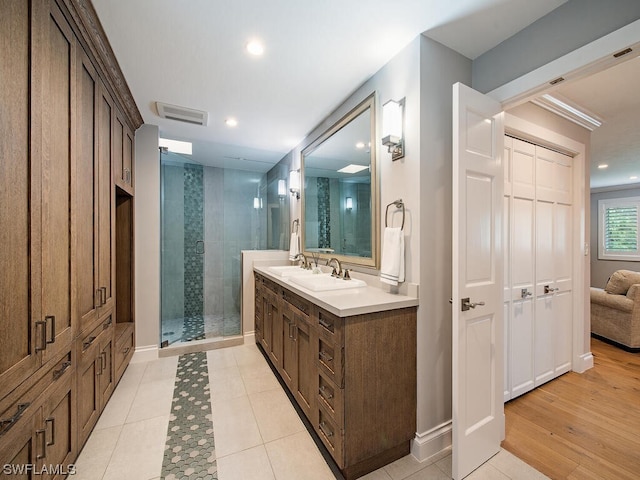 bathroom featuring tile patterned flooring, vanity, and a shower with door