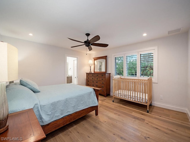bedroom featuring hardwood / wood-style floors, ceiling fan, and ensuite bathroom
