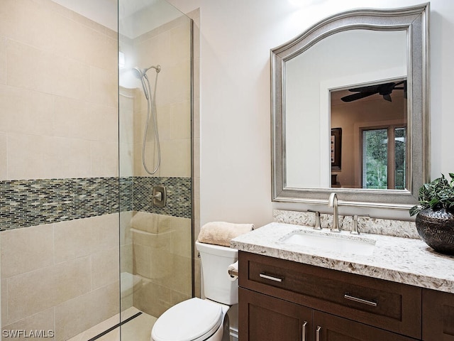 bathroom featuring an enclosed shower, ceiling fan, toilet, and vanity