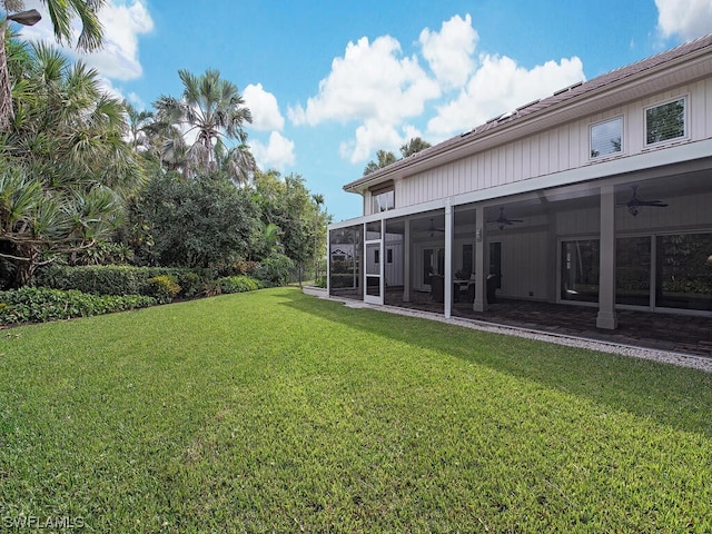 view of yard with a sunroom and ceiling fan