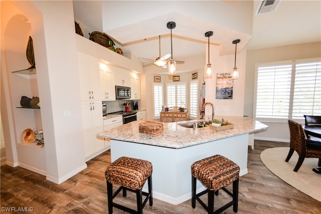 kitchen with white cabinets, stainless steel appliances, hanging light fixtures, and sink