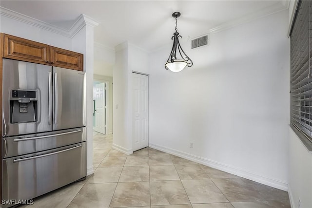 kitchen with hanging light fixtures, crown molding, light tile patterned flooring, and stainless steel fridge