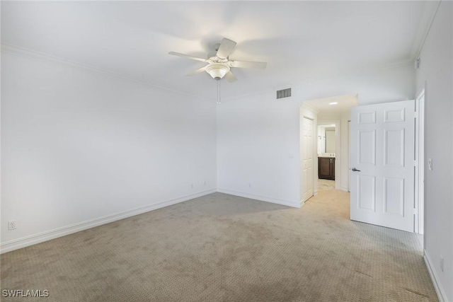 unfurnished room with crown molding, light colored carpet, and ceiling fan