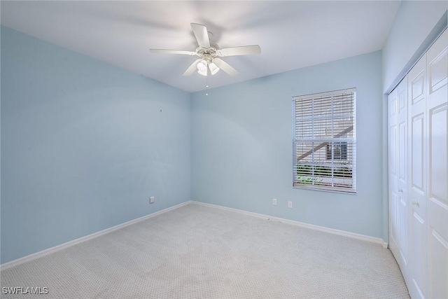 carpeted spare room featuring ceiling fan