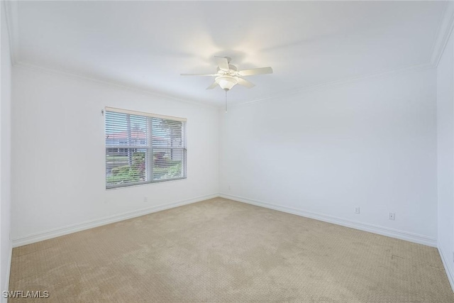 carpeted spare room featuring crown molding and ceiling fan