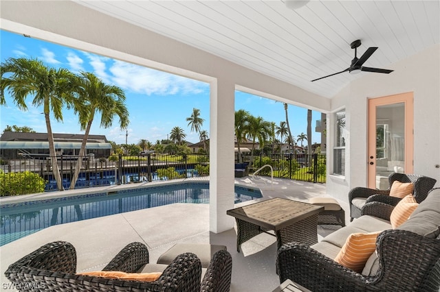 view of swimming pool with ceiling fan, a patio area, and a water view