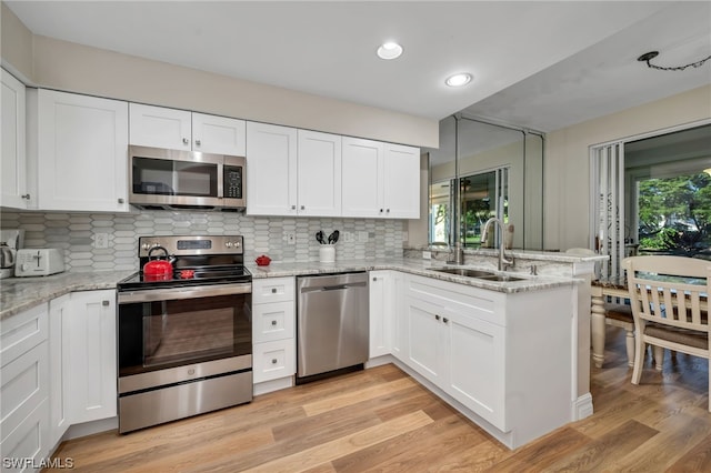 kitchen with white cabinets, stainless steel appliances, and plenty of natural light