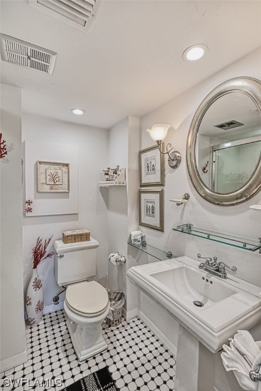 bathroom with toilet and tile floors