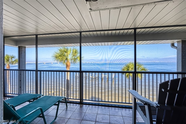 unfurnished sunroom featuring a water view