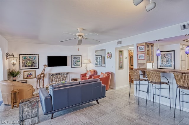 living room featuring light tile floors and ceiling fan