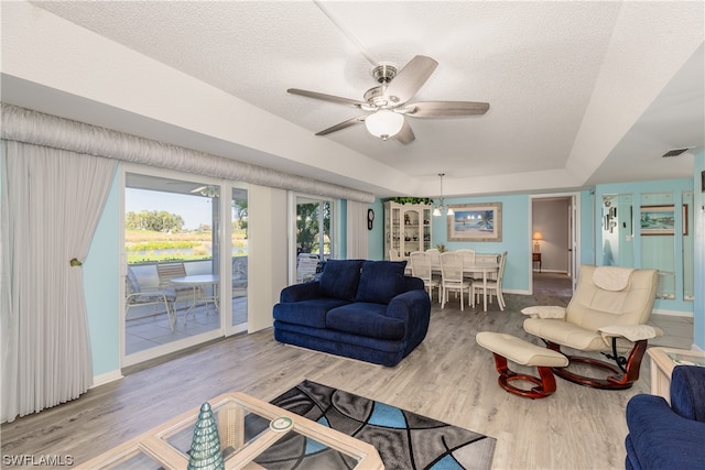 living room with hardwood / wood-style floors, a textured ceiling, and ceiling fan