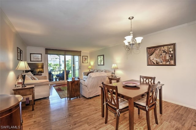 dining area featuring light hardwood / wood-style flooring, a notable chandelier, and crown molding