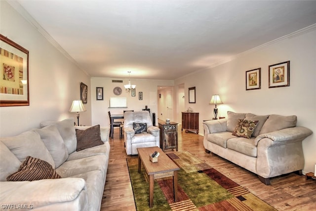 living room featuring a notable chandelier, dark hardwood / wood-style floors, and ornamental molding