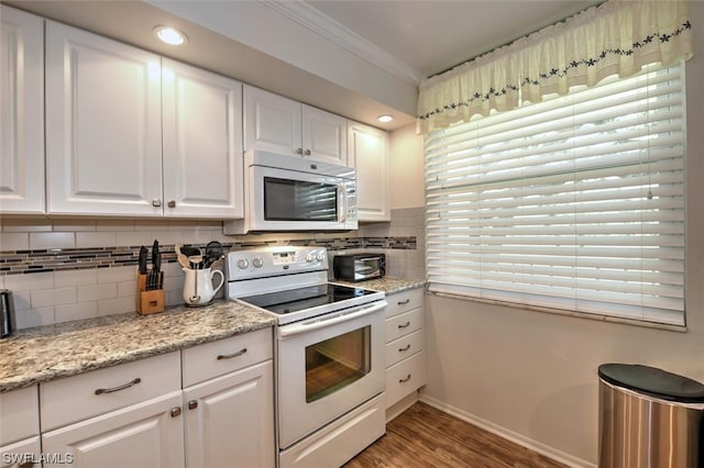 kitchen featuring white appliances, light stone counters, white cabinets, tasteful backsplash, and light wood-type flooring