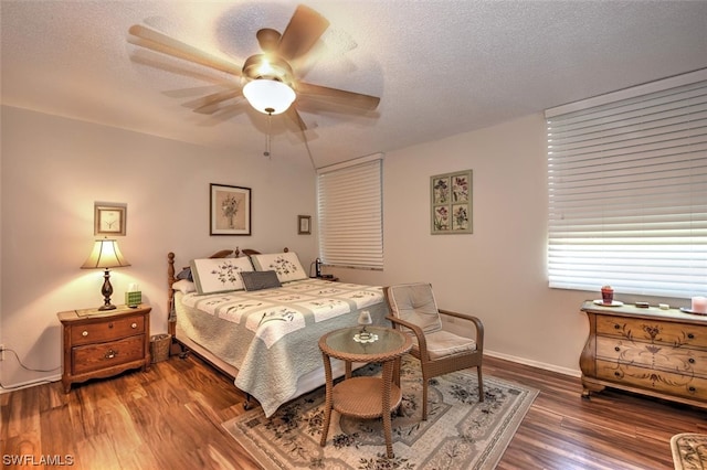 bedroom featuring ceiling fan, dark wood-type flooring, and a textured ceiling