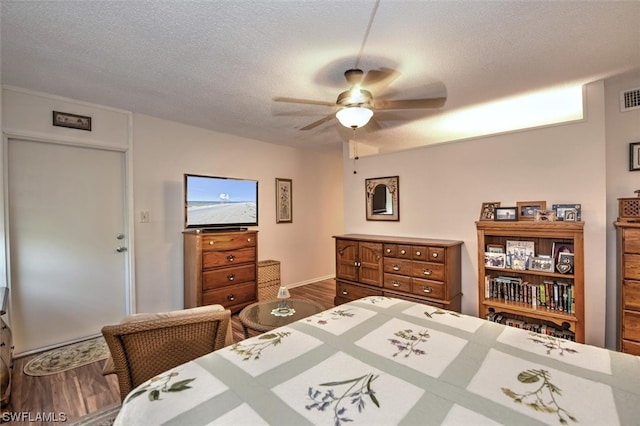 bedroom featuring a textured ceiling, wood-type flooring, and ceiling fan